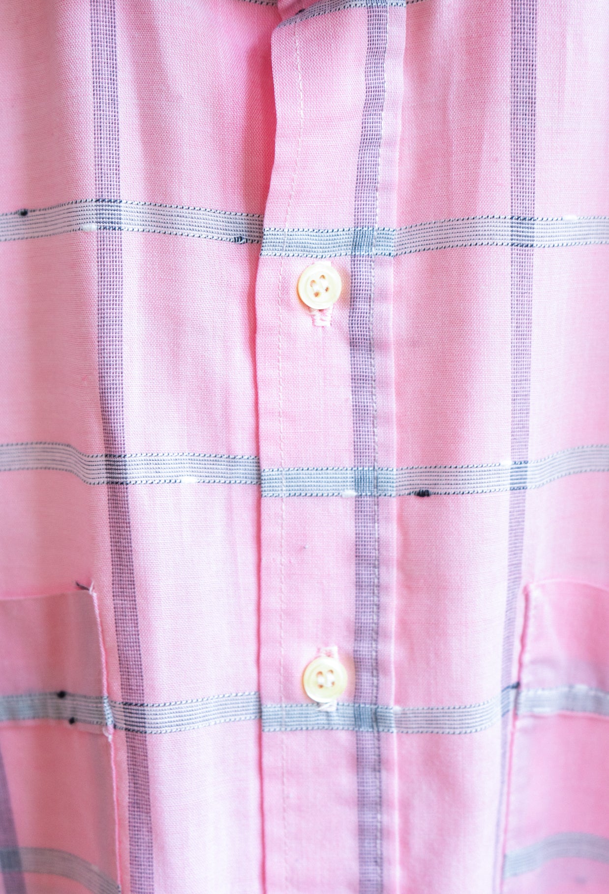 Close-up of soft pink checkered vintage shirt with with lines and buttons in LGBTQ- style fresh vintage