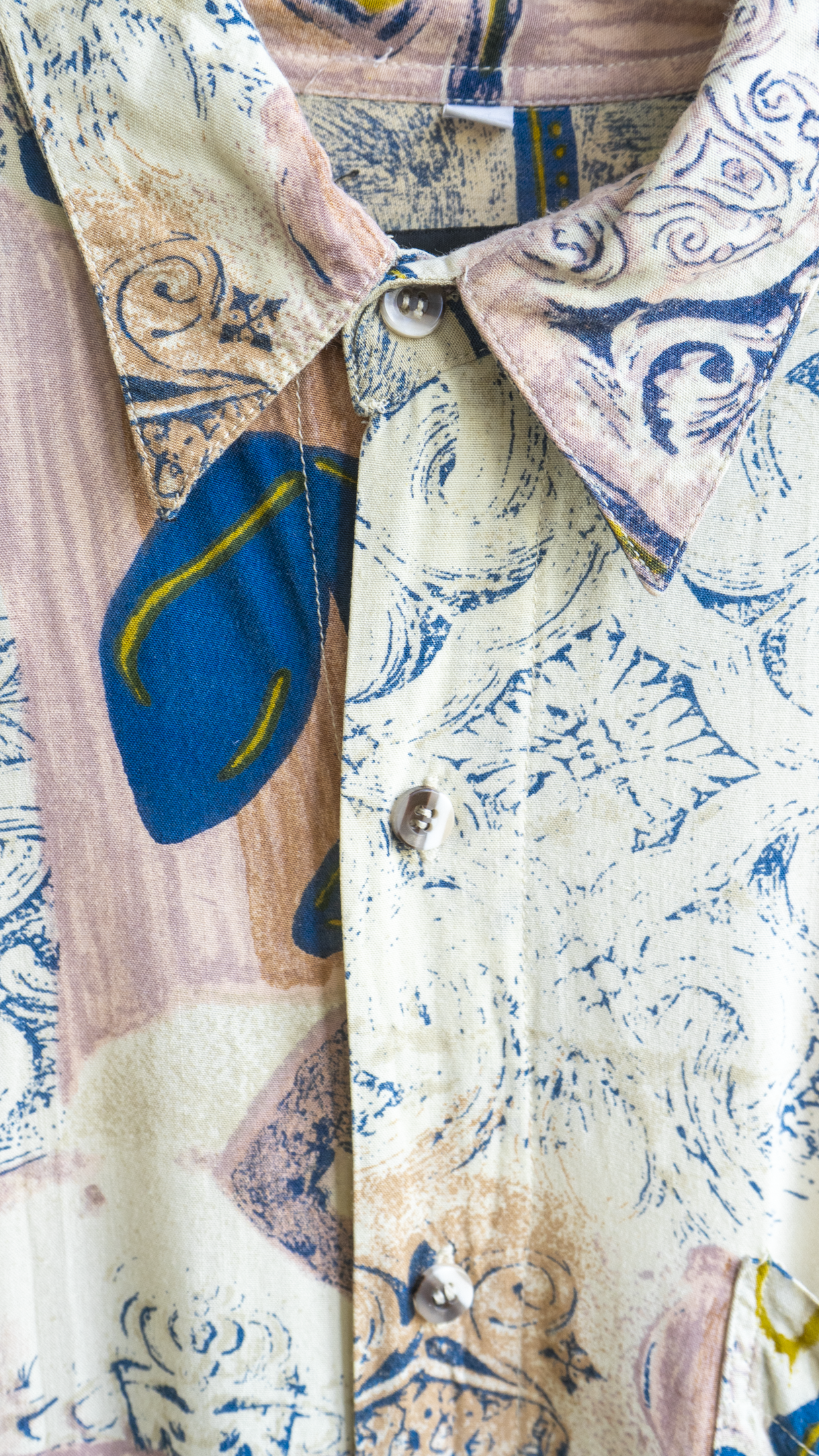 close up of a pink patterned vintage shirt with beige blue and hints of yellow by the Fresh Vintage brand