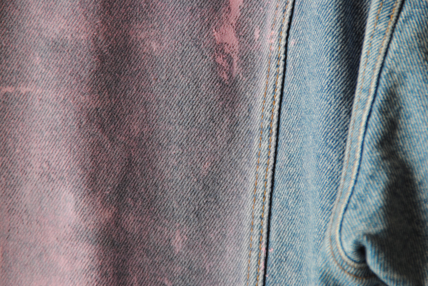 lichte vintage jeansjas met zachtroze verf ingezoomd