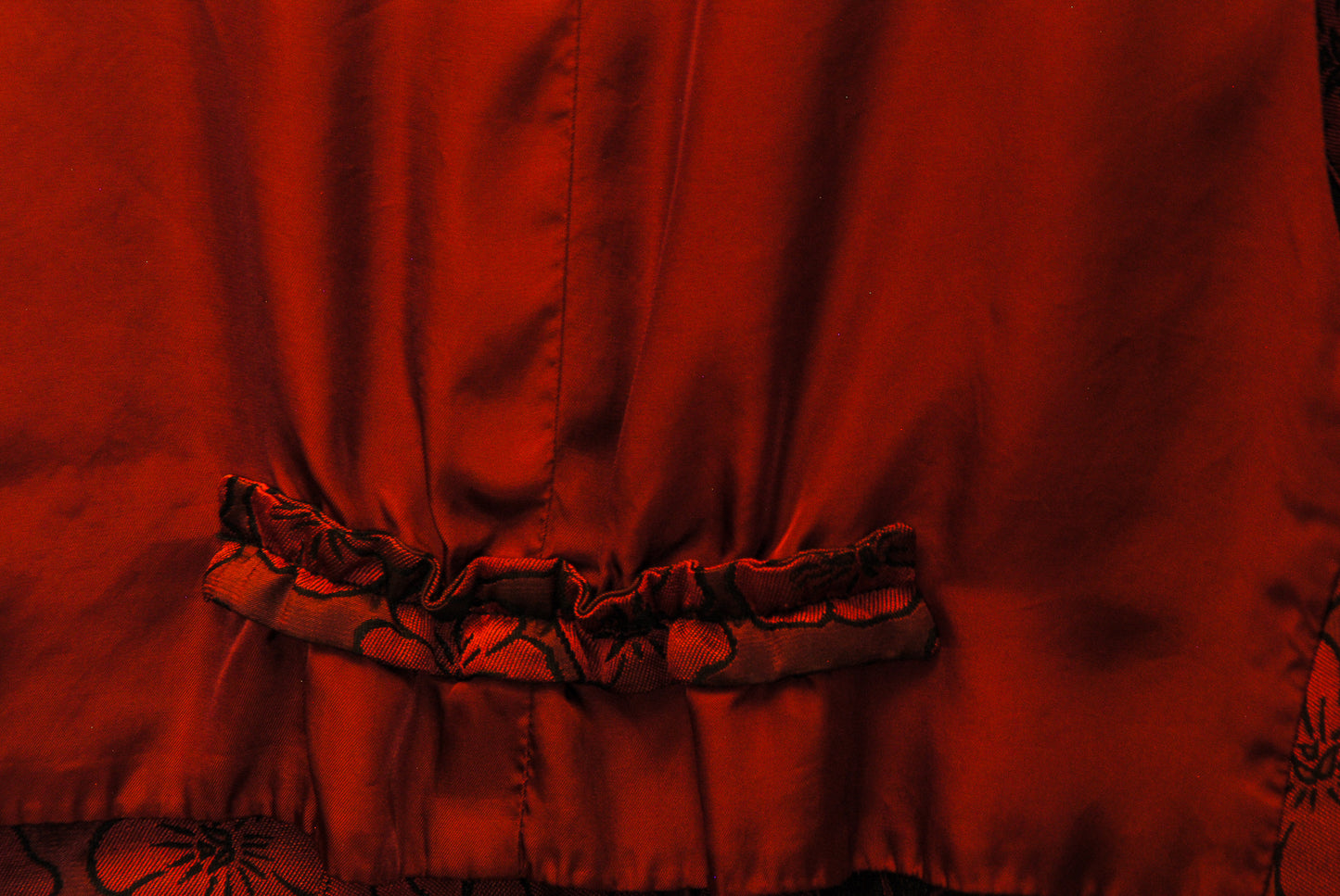 jaren-90-gilet-in-bordeaux-met-bloemen-patroon-ingezoomd-achterkant-rijkelijke-stof