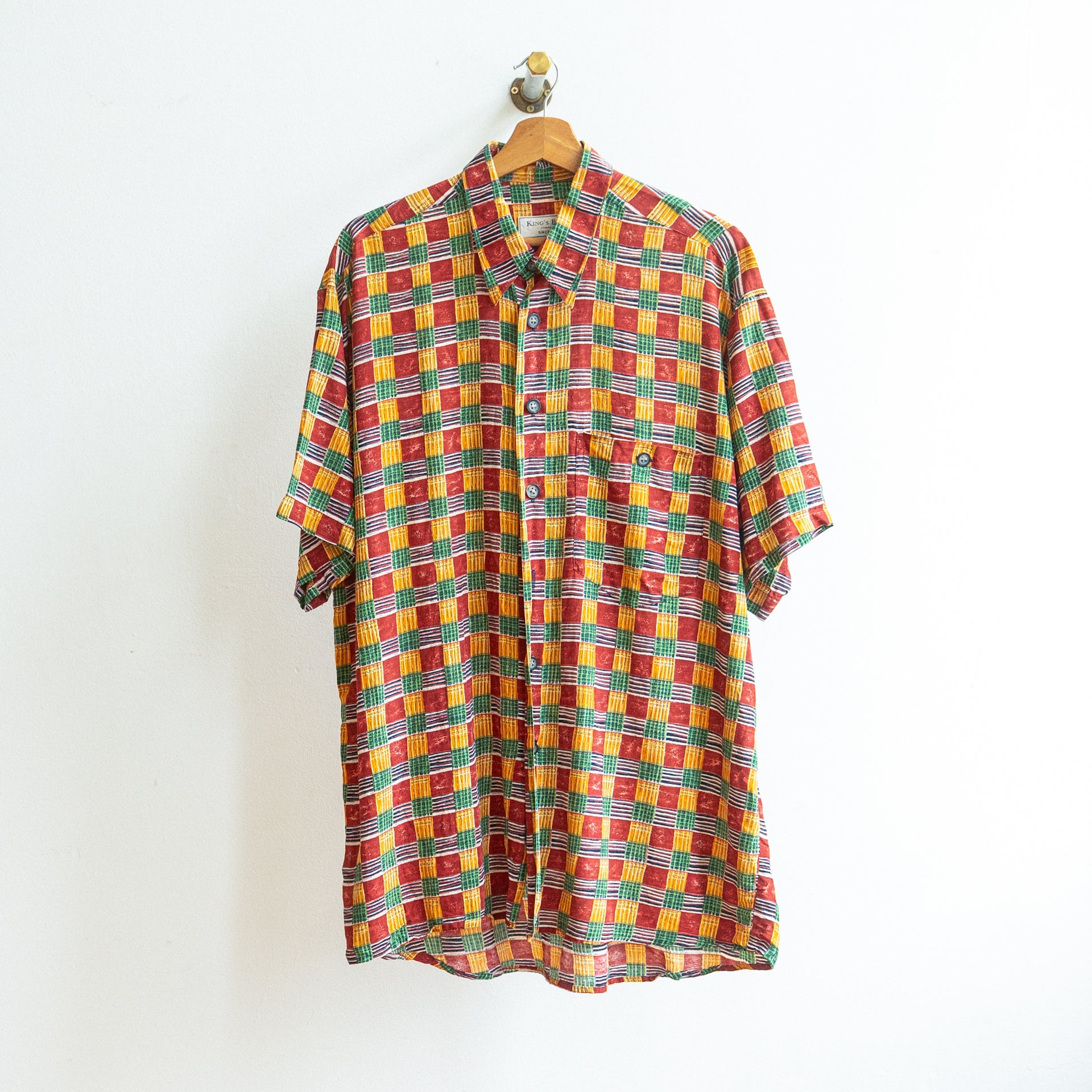 jaren 90 vintage hemd met vierkante ruiten in oranje groen bordeaux en wit merk fresh vintage aan kapstok 