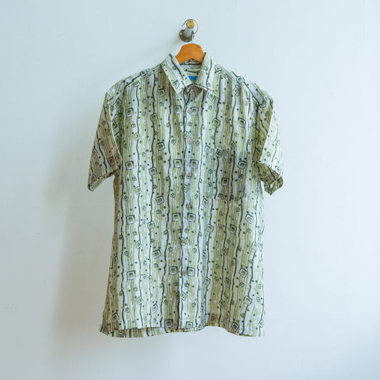 Short-sleeve vintage shirt from the 90s in white and khaki with abstract pattern of lines and squares for an underground look on a hanger