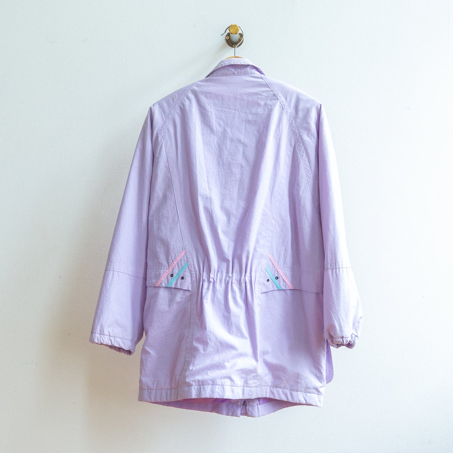 back of light purple 1980s coat with light pink and aqua color details