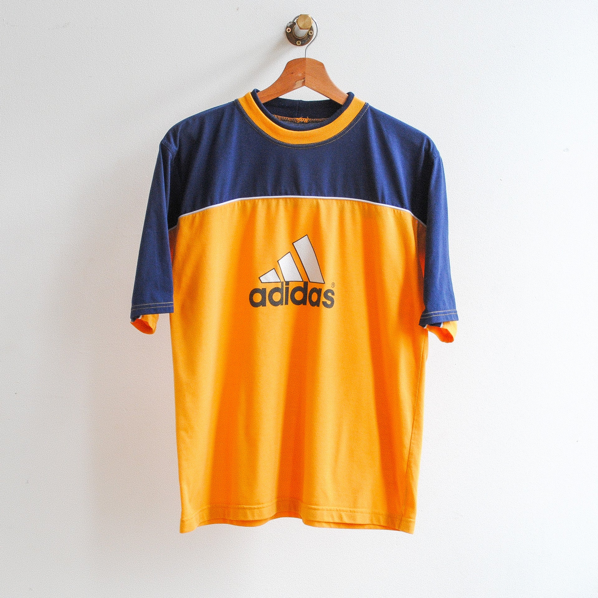 vintage adidas thirt with adidas logo in the middle top half of t-shirt blue with orange collar bottom orange cotton fabric
