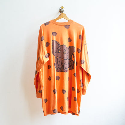 Oranje vintage oversized japon met lange mouwen en een afbeelding van een olifant en olifantenpootjes rondom aan een kapstok