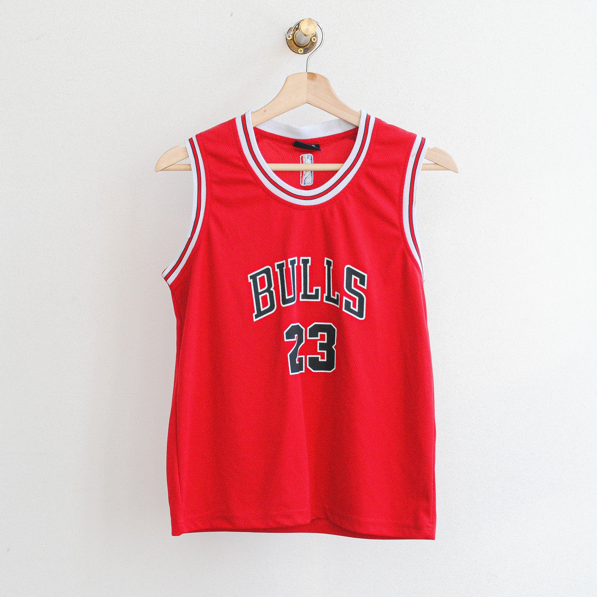 rode basketbal jersey met zwarte tekst bulls en nummer 23