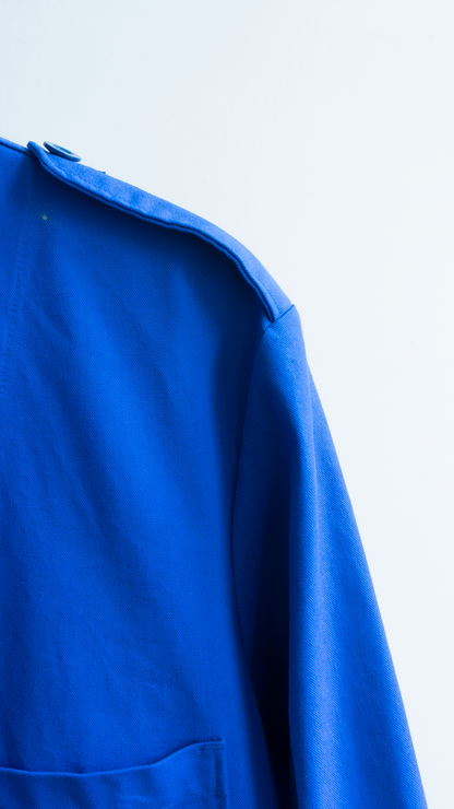 detail of fabric and should of a long blue vintage worker coat in a french style