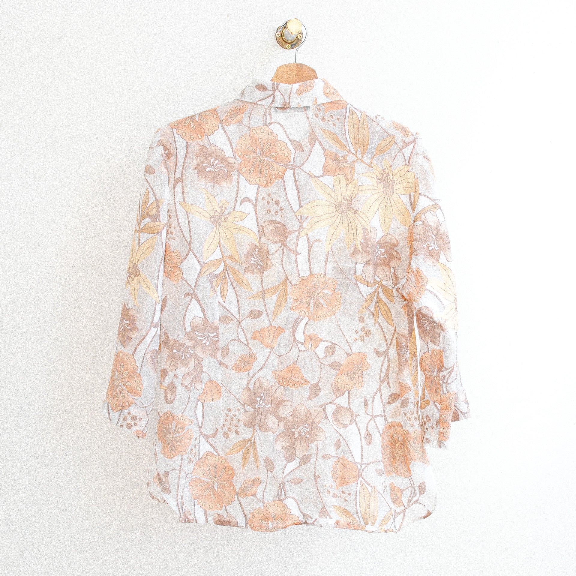 the back of a white vintage modissimo see-through vintage blouse with beige and orange flowers which is made in france