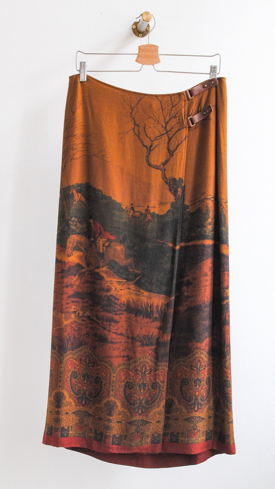 lange bruine vintage yves saint laurent rok met kleine leren bruinen gespen bovenaan en lopende paarden met jockeys in de natuur afgebeeld