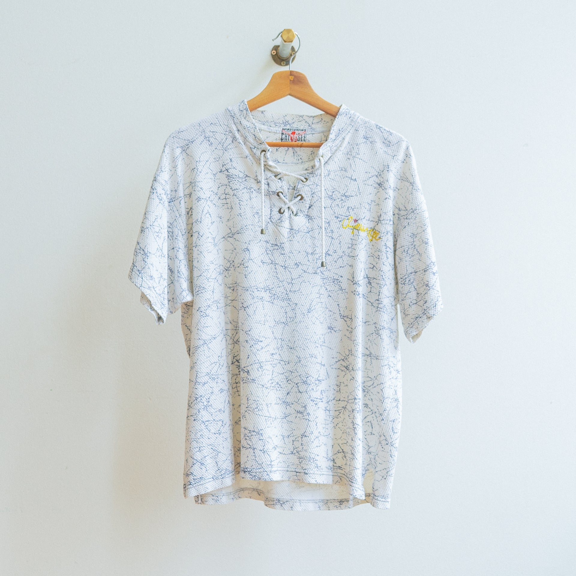 witte vintage tshirt met blauw gekrakeld patroon en trekkoord aan de hals in stof met textuur