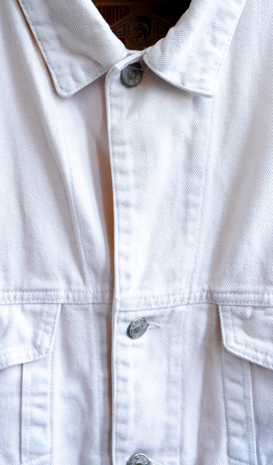 detail of a diesel white vintage jacket of the buttons and part of pocket