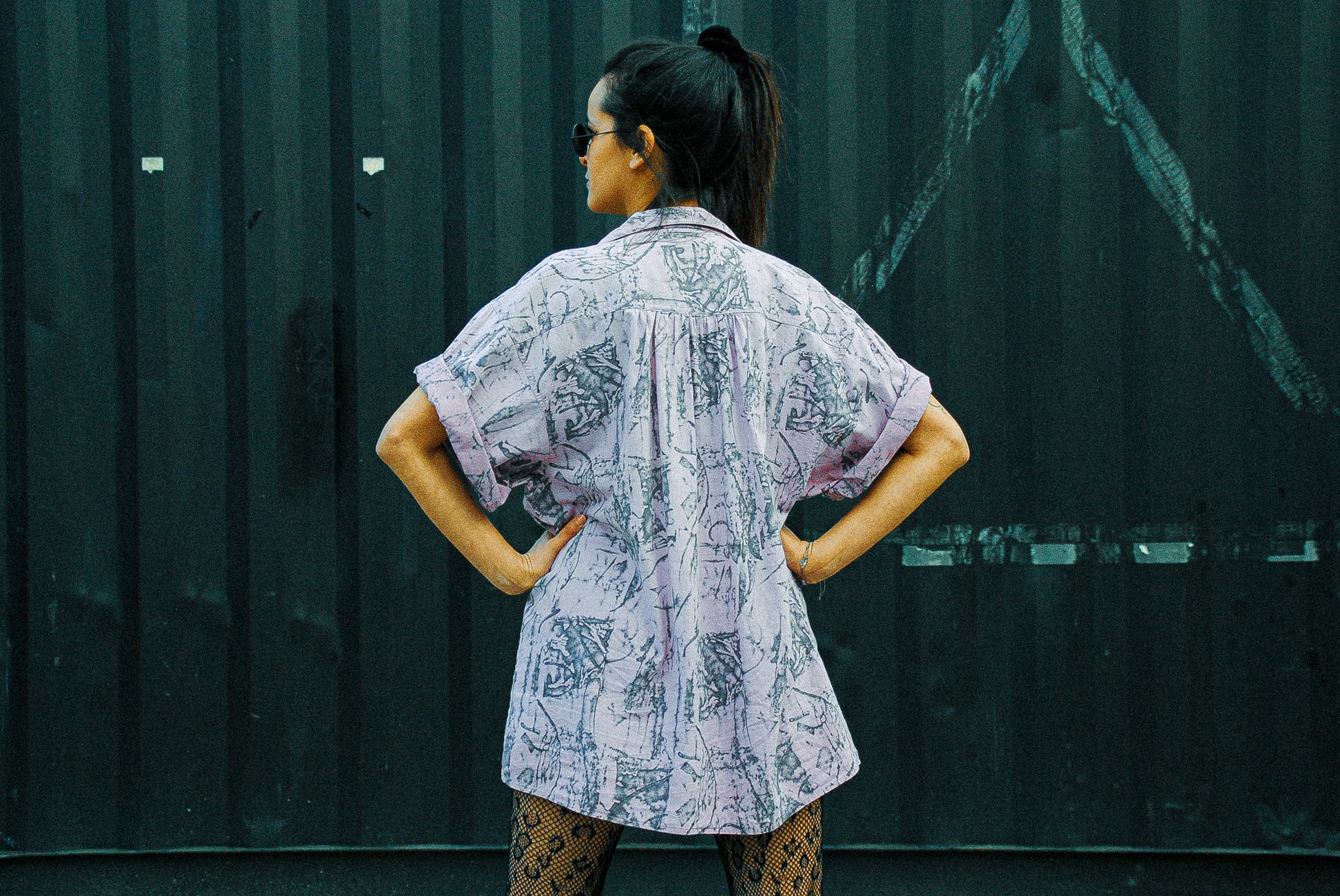 achterkant-paars-vintage-hemd-model-voor-container-met-handen-in-zij